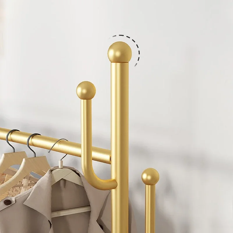 Portant à vêtements en métal doré avec roulettes et étagère de rangement